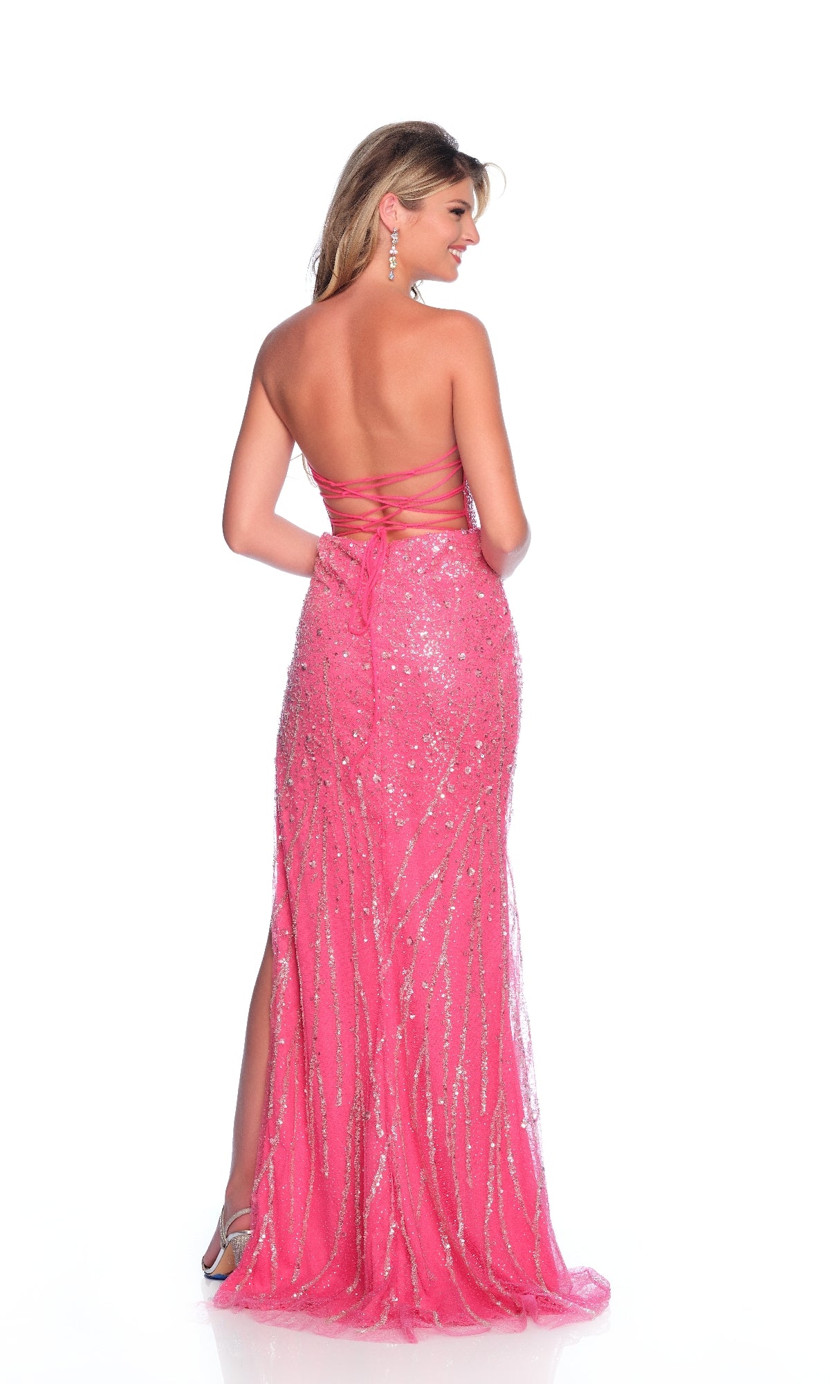 A woman faces away, wearing the Strapless Pink Prom Dress: Dave & Johnny 12243—a floor-length, bright sequined gown with an open back and side slit.